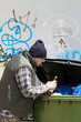 Foto: Tramp digging in dumpster Tramp digging in dumpster