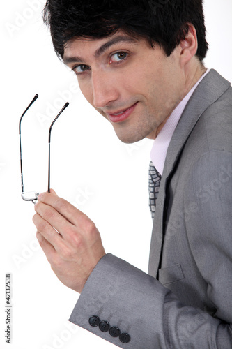 Photo: Businessman holding his glasses Businessman holding his glasses
