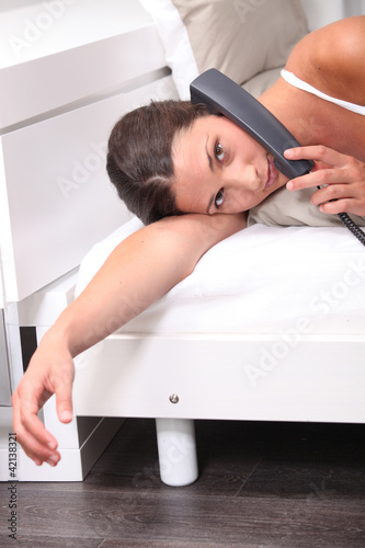 Photo: woman in bed talking on the phone woman in bed talking on the phone