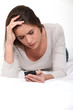 Frowning woman looking at her mobile phone