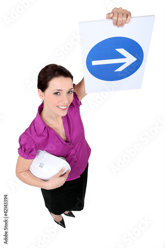Photo: Woman showing road sign of obligation to turn right Woman showing road sign of obligation to turn right