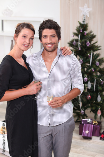 Foto: Couple in front of a Christmas tree Couple in front of a Christmas tree