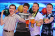 Foto: Four happy men hold balls and glasses of beer and cocktail Four happy men hold balls and glasses of beer and cocktail