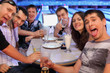 Foto: Friends sit at table and drink beer and cocktails in bowling Friends sit at table and drink beer and cocktails in bowling