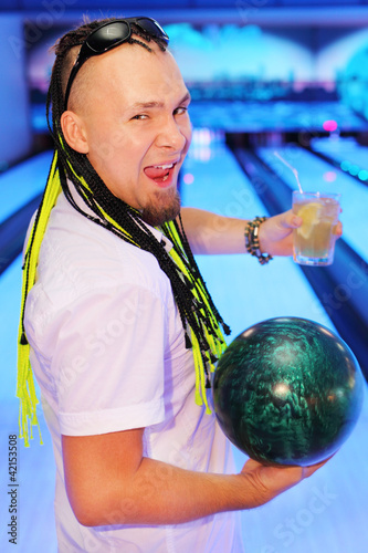 Photo: Happy young man shouts, holds ball and glass of cocktail Happy young man shouts, holds ball and glass of cocktail