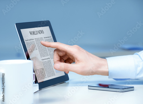 Photo: Analyzing business news on modern device Analyzing business news on modern device