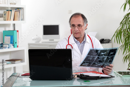 Photo: Doctor looking at an xray Doctor looking at an xray