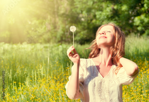 Photo: beautiful girl with dandelion enjoying the summer sun beautiful girl with dandelion enjoying the summer sun