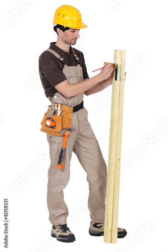 Photo: Tradesman using a try square to measure an angle Tradesman using a try square to measure an angle