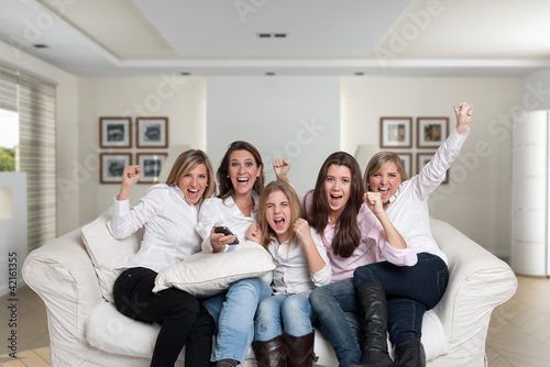 Photo: Women cheering on the sofa Women cheering on the sofa