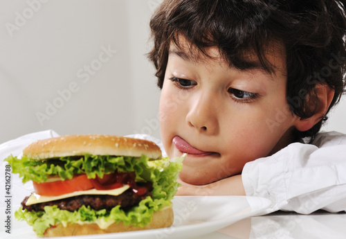 Photo: Boy on temptation with burger Boy on temptation with burger