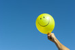 Photo: Arm with happy smiley balloon Arm with happy smiley balloon