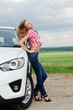 The beautiful girl stands near to white car