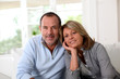 Portrait of happy senior couple sitting in sofa