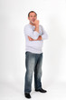 Senior man standing on white background with hand on chin