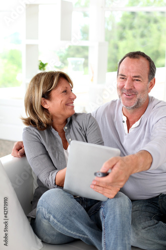 Photo: Senior married couple choosing movie on tv Senior married couple choosing movie on tv