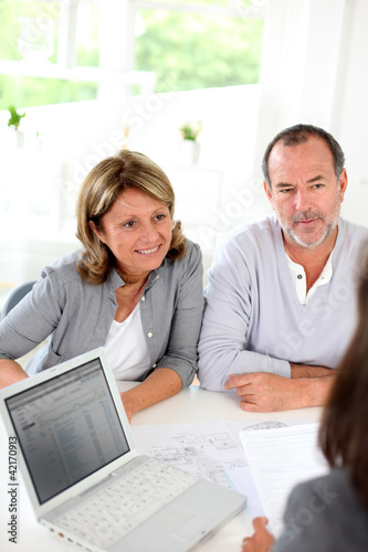 Photo: Senior couple ready to buy new house reading contract Senior couple ready to buy new house reading contract