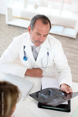 Foto: Doctor with patient looking at X-ray Doctor with patient looking at X-ray