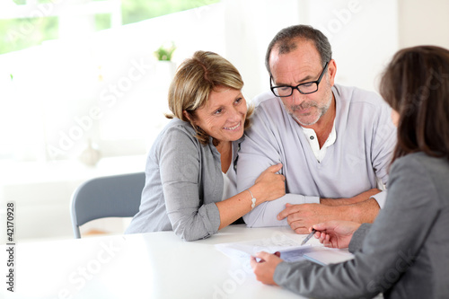 Foto: Senior couple signing financial contract Senior couple signing financial contract