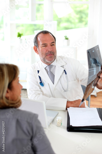 Foto: Doctor with patient looking at X-ray Doctor with patient looking at X-ray