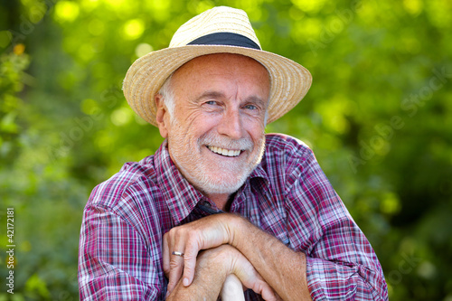 Photo: Happy senior gardener with straw hat Happy senior gardener with straw hat
