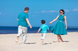 Photo: Young family of three having fun tropical beach Young family of three having fun tropical beach