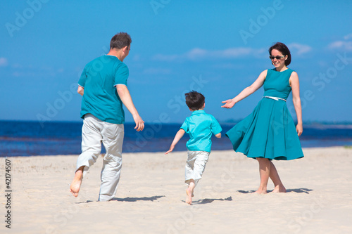 Foto: Young family of three having fun tropical beach Young family of three having fun tropical beach