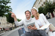 Couple visiting city with help of map and electronic tablet