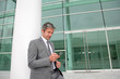 Businessman writing short message on mobile phone