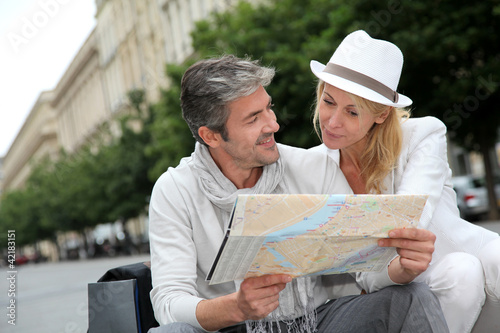 Photo: Middle aged couple looking at city map Middle aged couple looking at city map