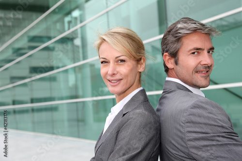Photo: Business people standing back to back Business people standing back to back