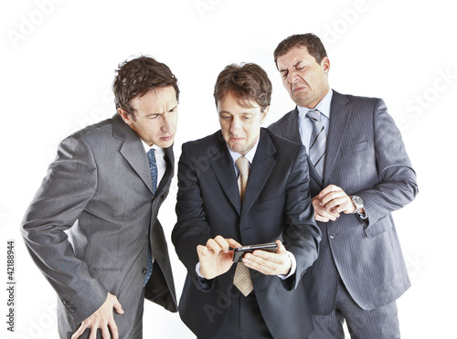 Foto: three businessmen looking at a smartphone three businessmen looking at a smartphone