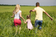 Photo: young family running across the field young family running across the field