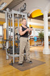 Mann in den Vierzigern trainiert Bizeps im Fitnessstudio