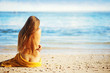 beautiful woman sitting from the back on beach, bali