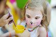 Foto: Adorable girl getting her face painted Adorable girl getting her face painted