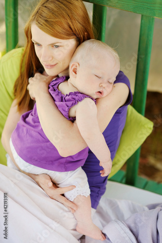 Photo: Eight months old baby sleeping in mothers hands Eight months old baby sleeping in mothers hands