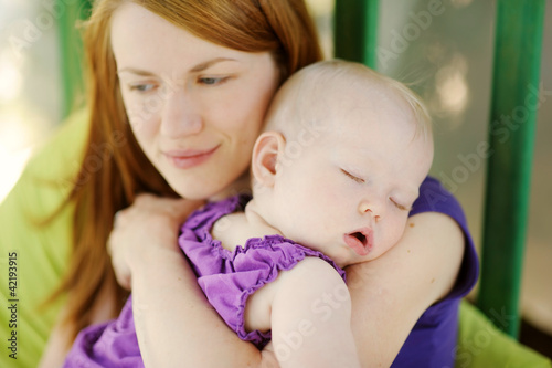 Photo: Eight months old baby sleeping in mothers hands Eight months old baby sleeping in mothers hands