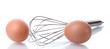 Metal whisk for whipping eggs and brown eggs isolated on white