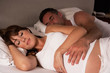 Pregnant woman and husband in bed
