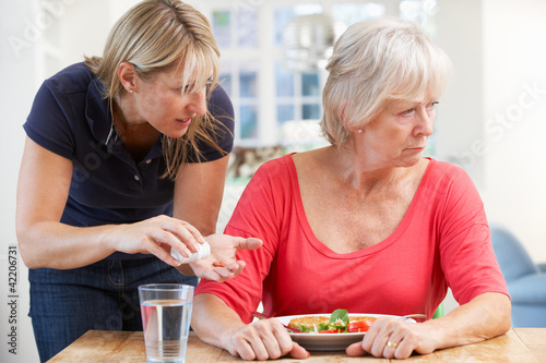 Photo: Older woman refusing medication at home Older woman refusing medication at home