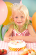 Young girl with birthday cake at party