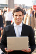 Photo: Male commuter in crowd using laptop Male commuter in crowd using laptop