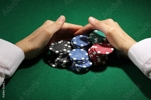 Foto: Taking win in poker on green table Taking win in poker on green table