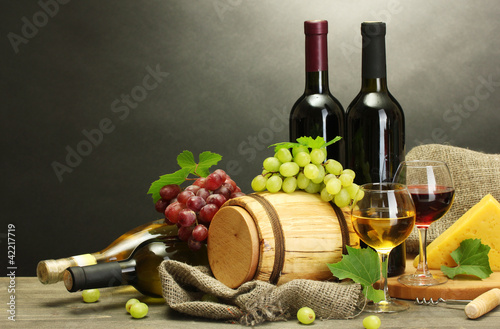 Foto: wine, cheese and grapes on wooden table on grey background wine, cheese and grapes on wooden table on grey background