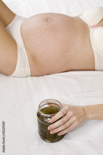 Photo: Pregnant woman holding jar of pickles Pregnant woman holding jar of pickles