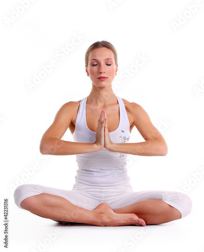 Photo: Young woman practicing yoga, sitting in a lotus position Young woman practicing yoga, sitting in a lotus position