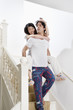 Young man carrying woman down the stairway