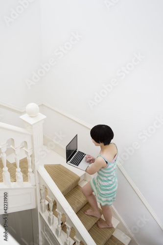 Photo: Young woman walking up with laptop in hands Young woman walking up with laptop in hands