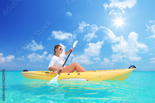 Photo: A female kayaking on a sunny day A female kayaking on a sunny day